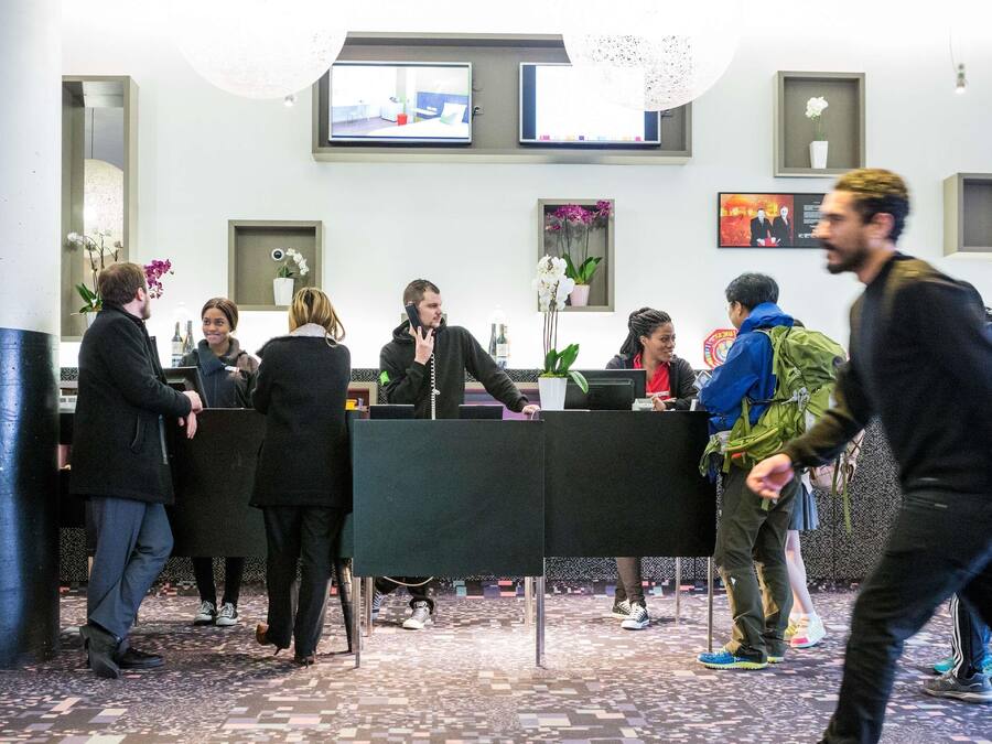 A reception area with a counter, seating, and a TV screen.