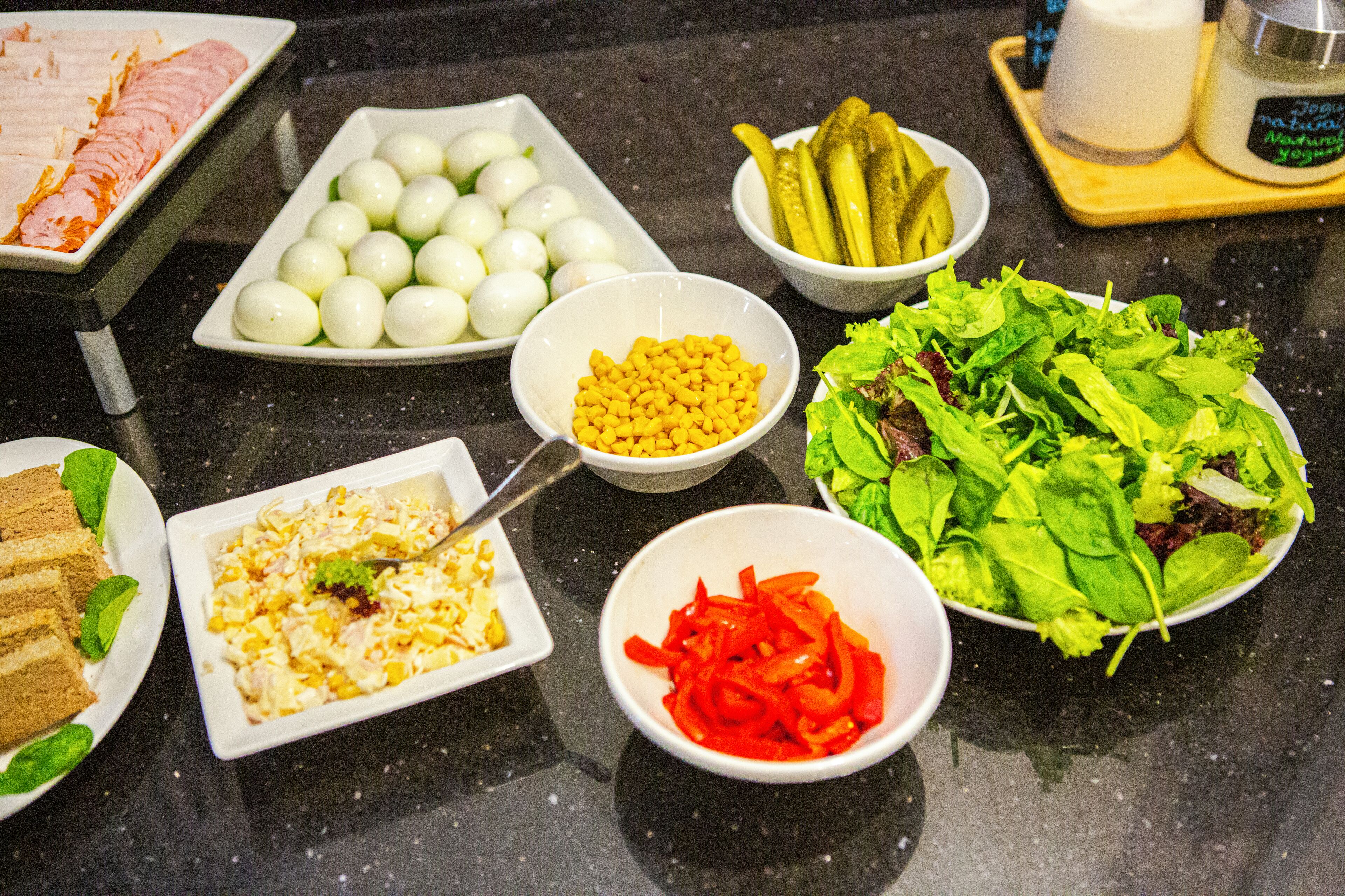 A table with various food items including eggs, pickles, and salad.