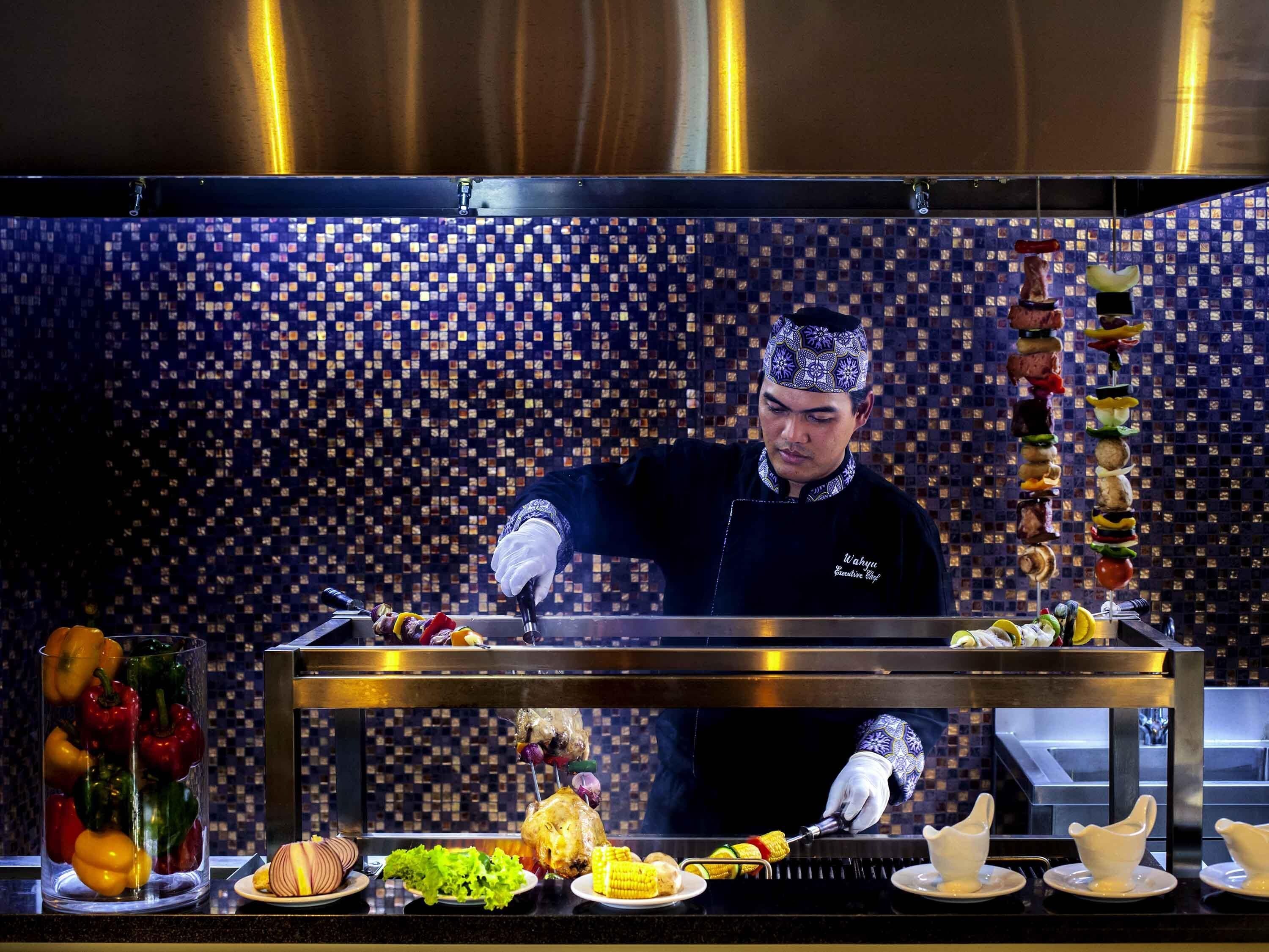 Un chef preparando comida en una cocina con salpicadero de azulejos.