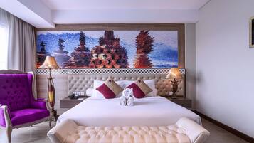 Habitación de hotel con una cama grande, un sillón morado, una lámpara decorativa y una obra de arte en la pared.