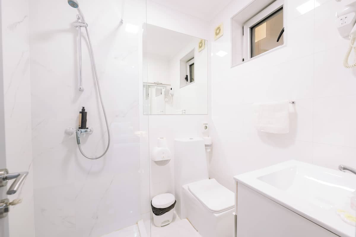 Un baño moderno con ducha, inodoro y lavamanos.