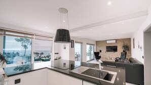 Una cocina moderna con una isla grande, una zona de comedor con vistas y un espacio de estar con chimenea.