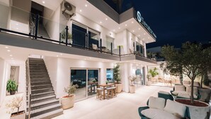 Un hotel moderno con un amplio patio exterior, una escalera que conduce al piso superior y un letrero con el nombre 'Senator'.