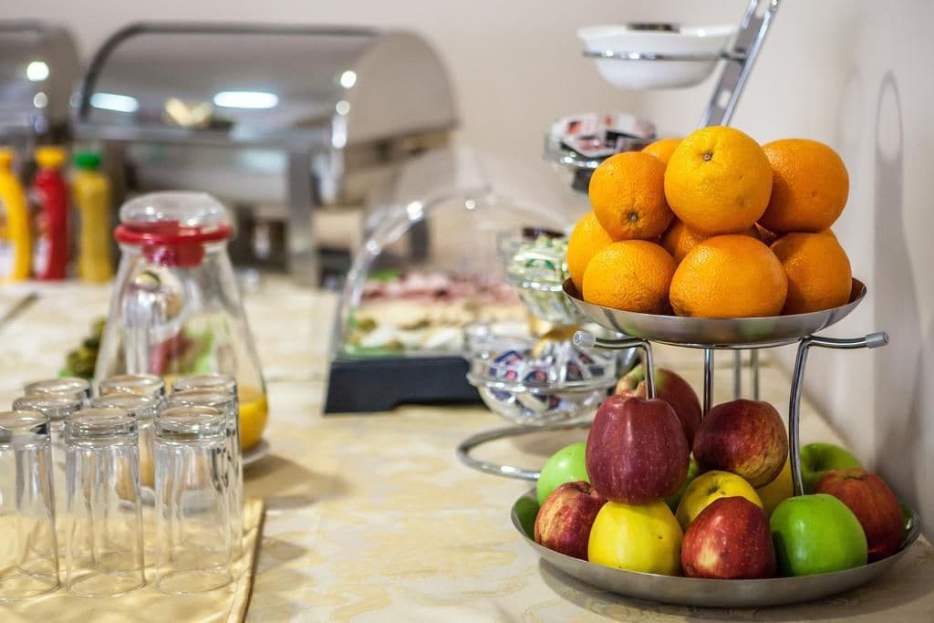 A buffet table with a variety of fruits and beverages.