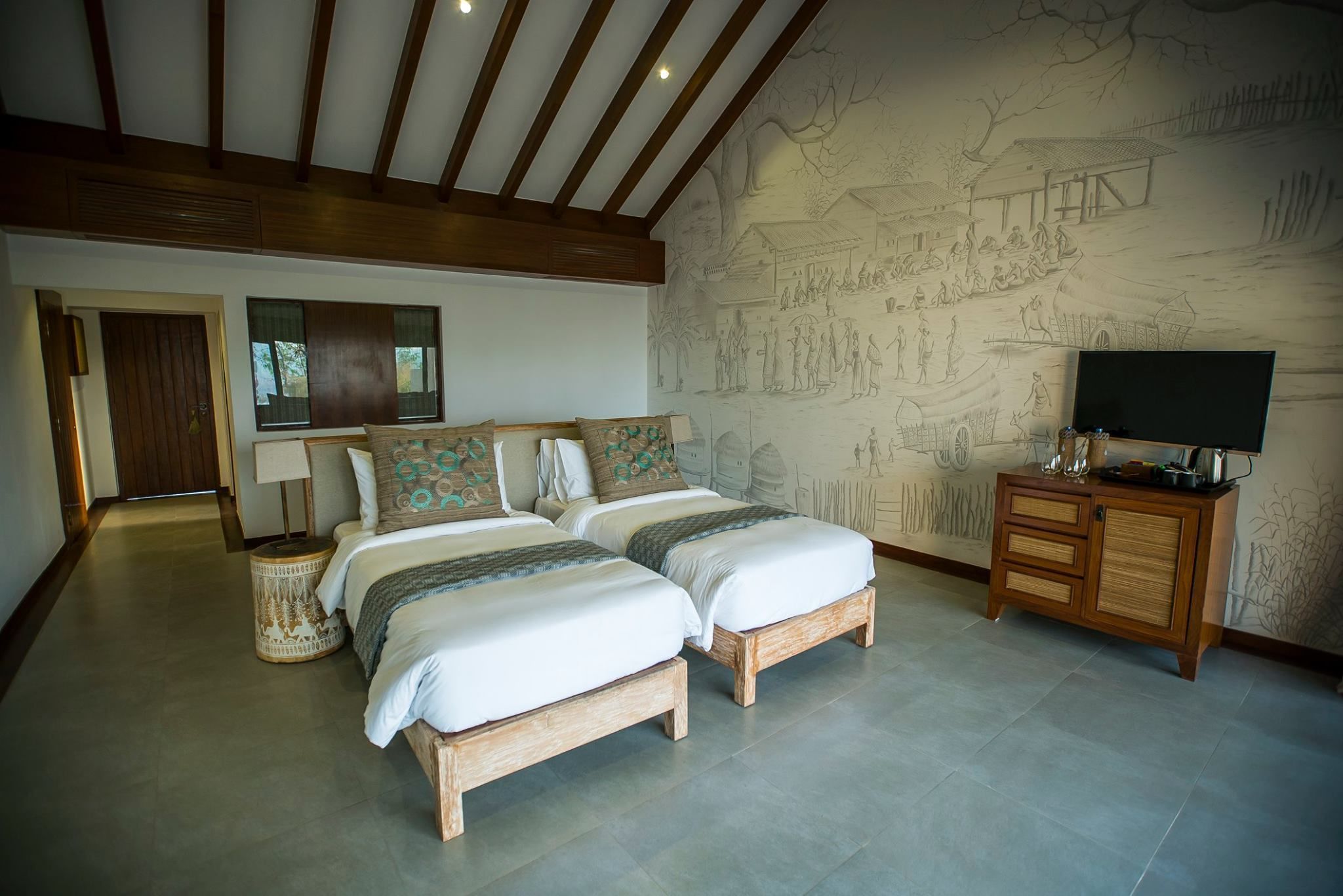 Un dormitorio con dos camas, un armario de madera y un mural en la pared.