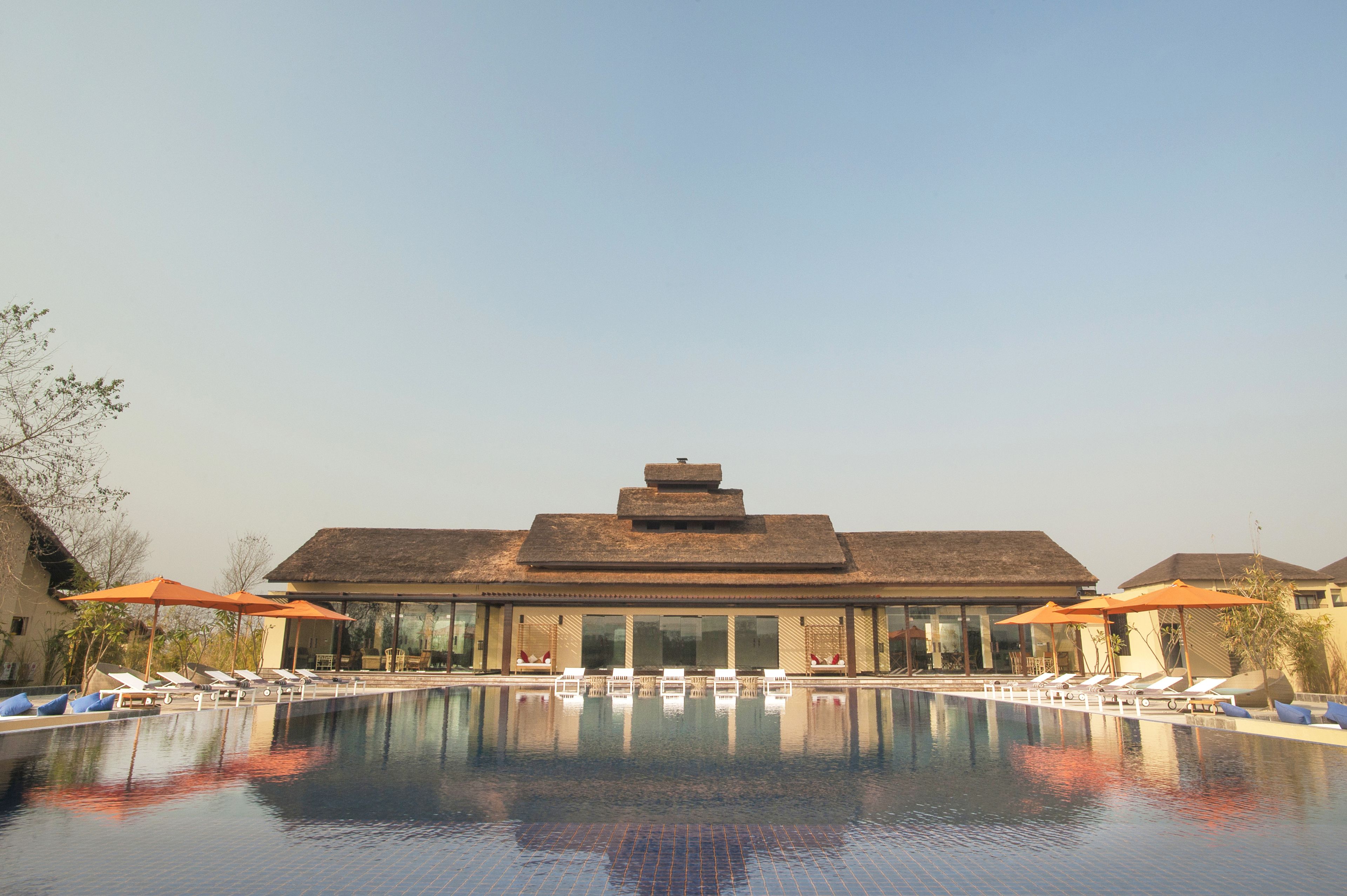 A resort with a large pool, lounge chairs, and umbrellas.