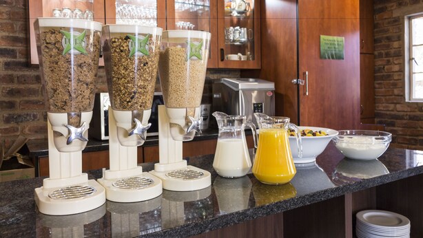 A kitchen with three grain mills, a milk jug, and a pitcher of orange juice on the counter. - Ruth Avenue Guest House (Edenvale)