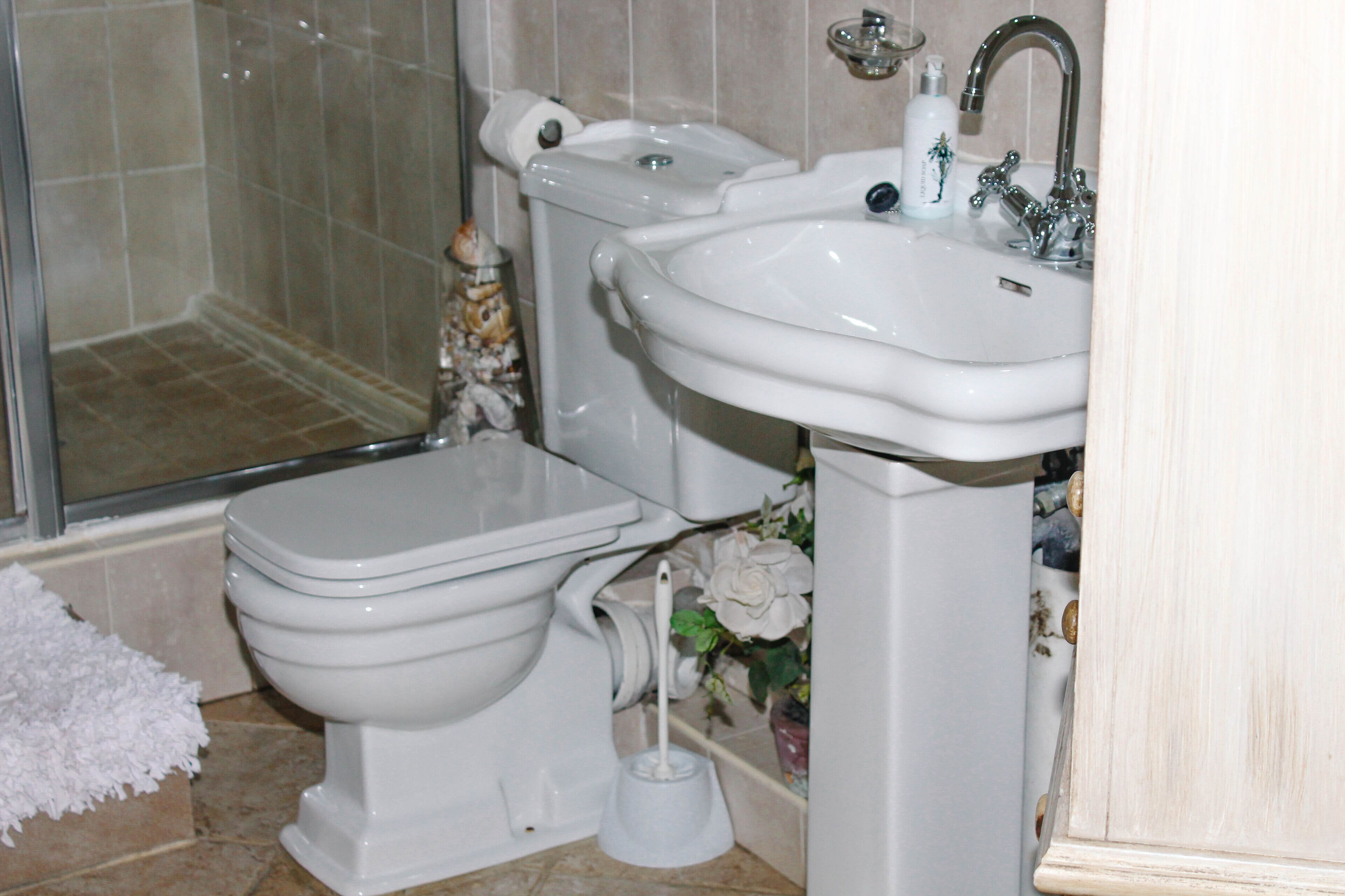 A bathroom with a toilet, bidet, sink, and shower.