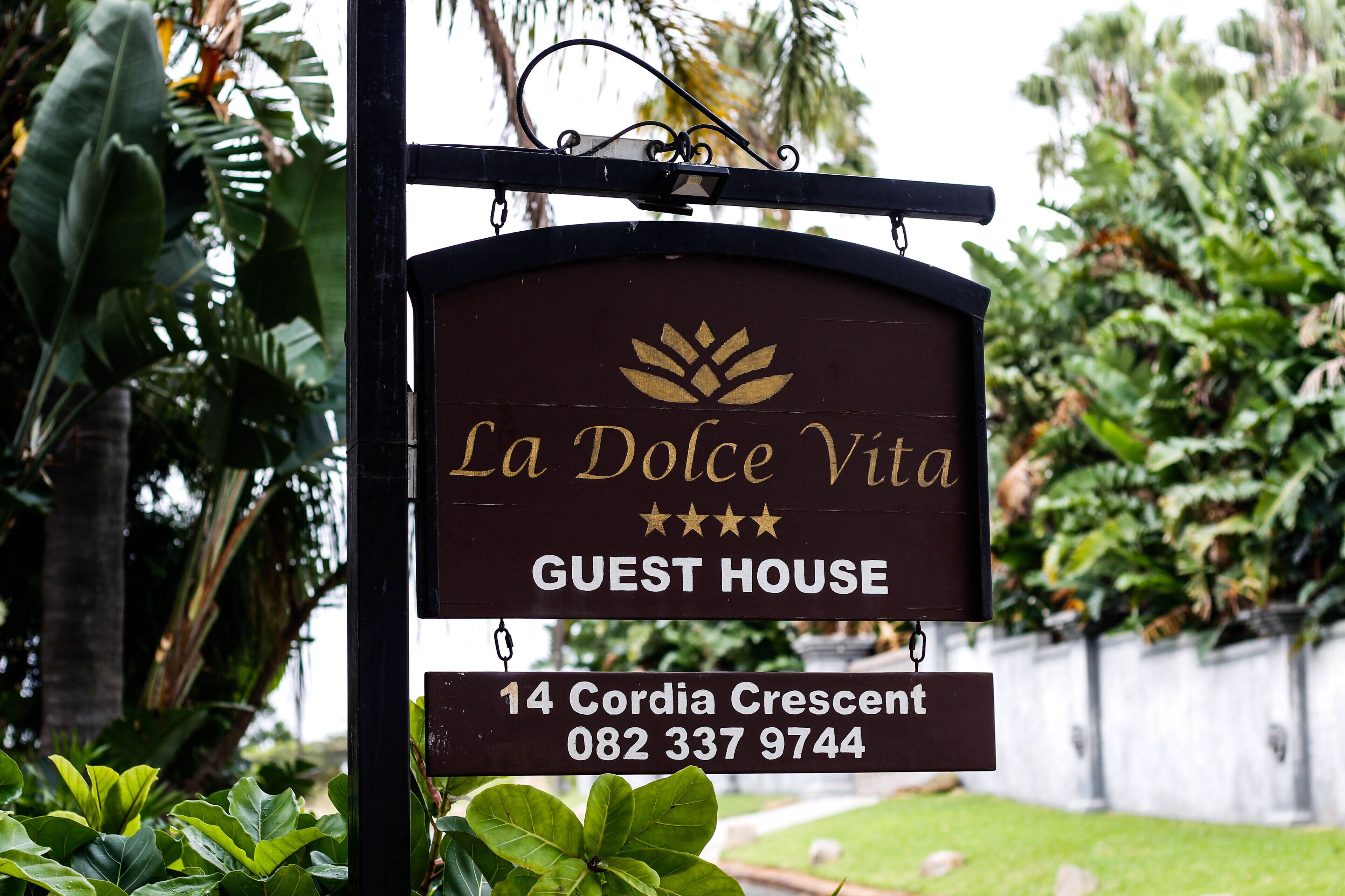 Schild für La Dolce Vita Guest House mit Adresse und Telefonnummer.