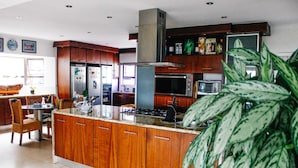 A modern kitchen with wooden cabinets, stainless steel appliances, and a large island.