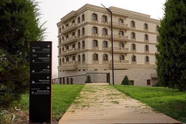 A multi-story building with a signpost indicating directions to various locations.