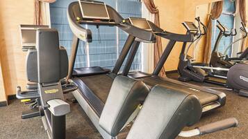 A gym with treadmills, stationary bikes, and a weight machine.