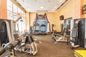 A gym with treadmills, weight machines, and a mirror wall. - Kainar Hotel (Shymkent)