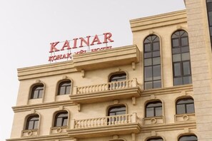 A building with a sign reading 'KAINAR HOTEL' at the top. - Kainar Hotel (Shymkent)