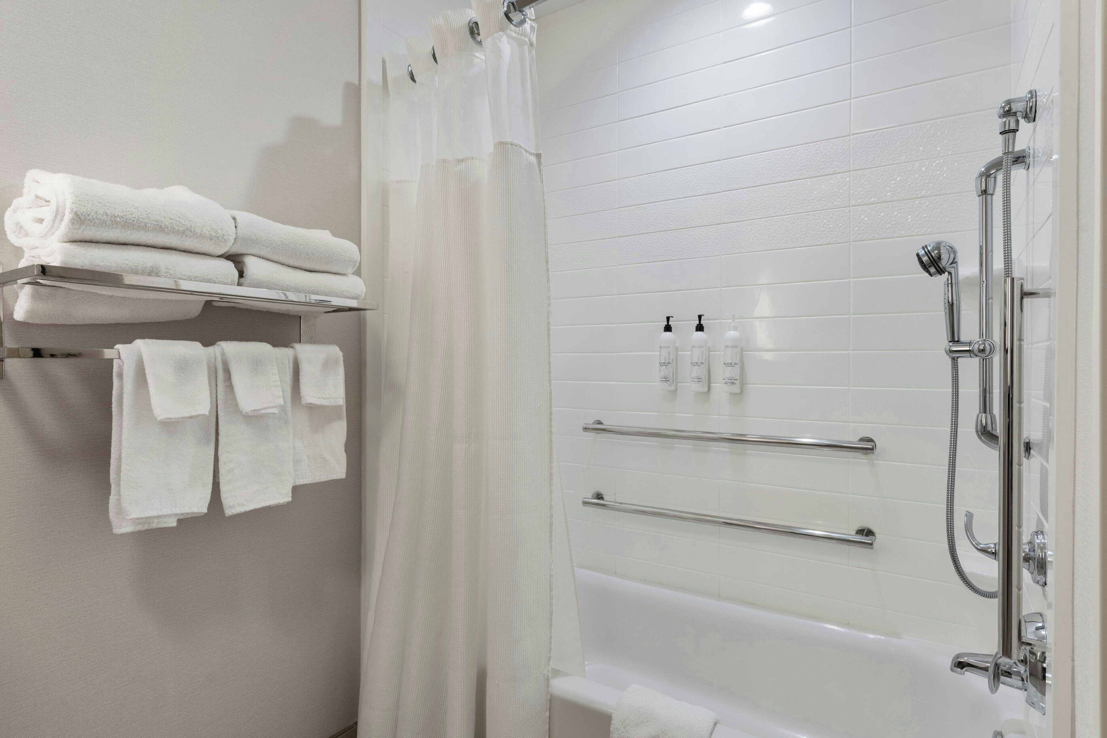 Une salle de bain moderne équipée d’une baignoire, d’une douche et d’un porte-serviettes.