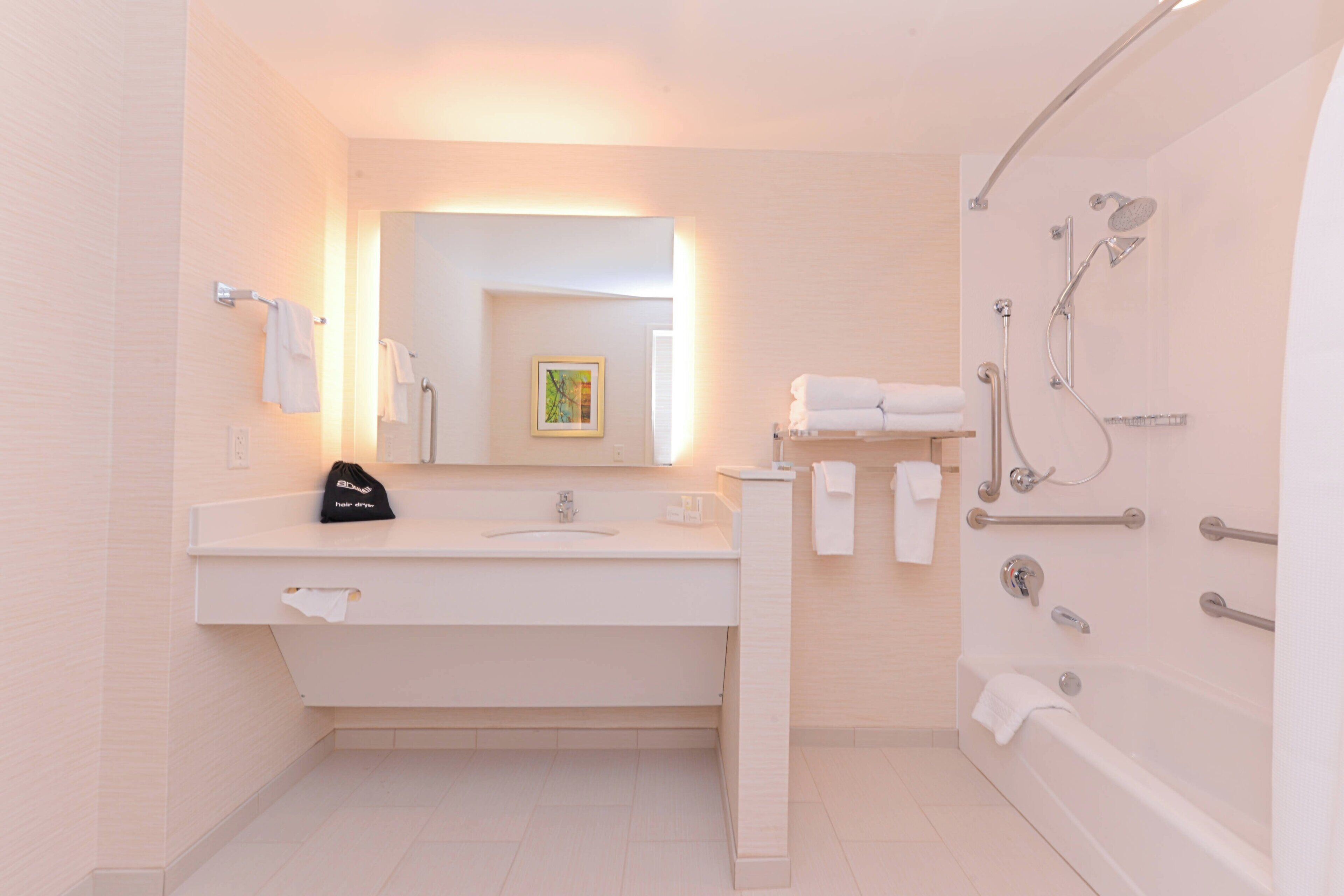 Une salle de bain moderne avec un lavabo, un miroir et une douche.