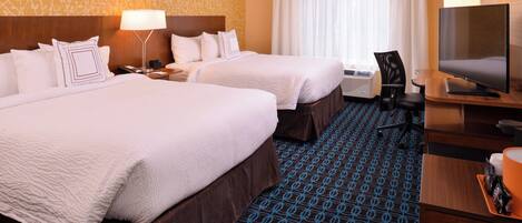 A hotel room with two beds, a TV, a desk, and a chair.