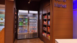 A corner market with refrigerated beverage coolers and snack shelves. - Fairfield by Marriott Inn & Suites Plymouth White Mountains (Plymouth)