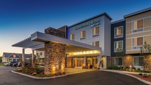 A Fairfield Inn & Suites Marriott hotel with a covered entrance, stone pillar, and a parking lot. - Fairfield by Marriott Inn & Suites Plymouth White Mountains (Plymouth)