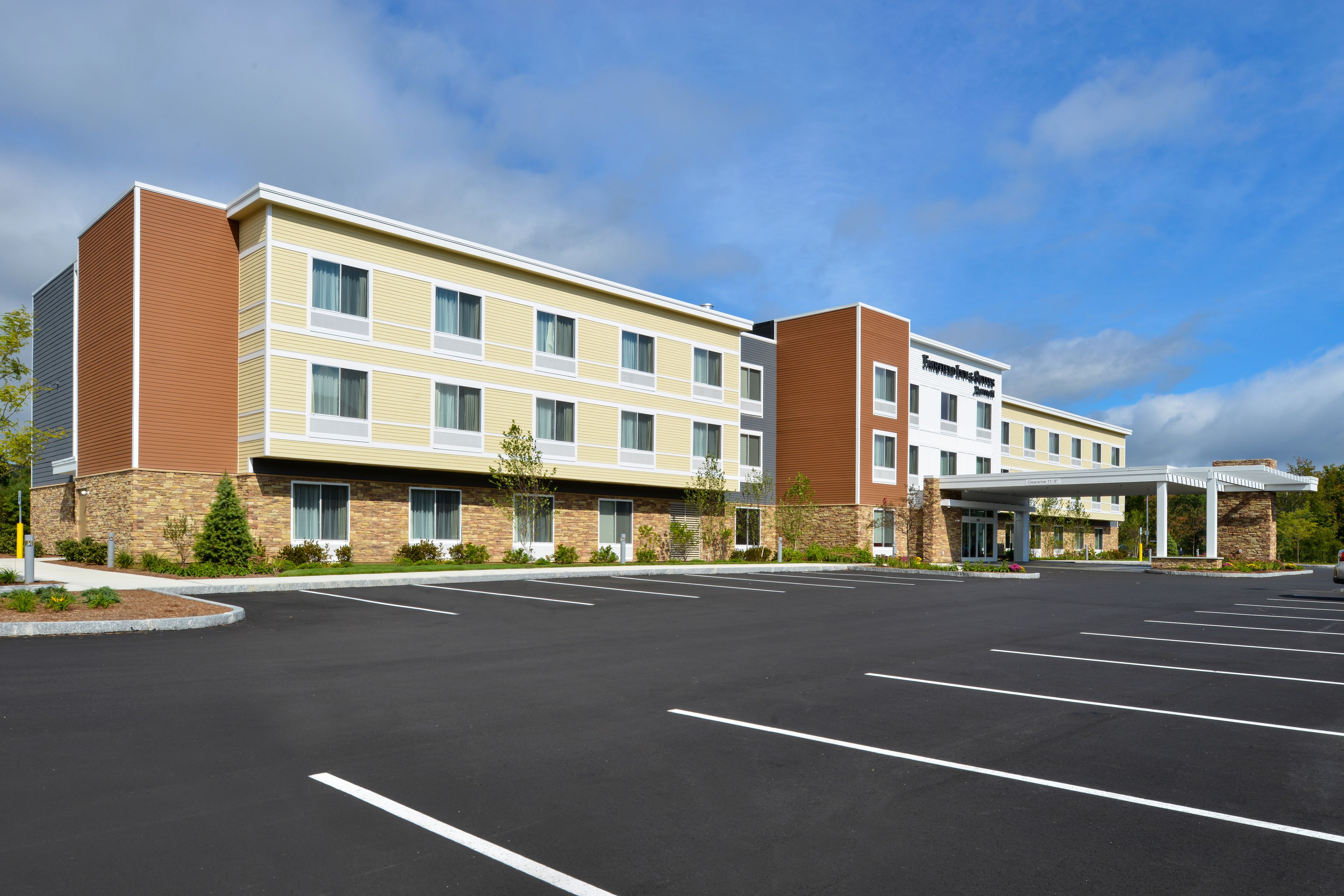 A multi-story hotel with a parking lot in front.