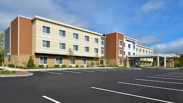 A multi-story hotel with a parking lot in front.