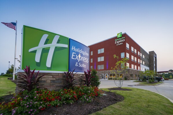 A Holiday Inn Express & Suites building with a prominent sign, landscaped garden, and parked cars. - Holiday Inn Express & Suites Southaven Central - Memphis by IHG (Southaven)