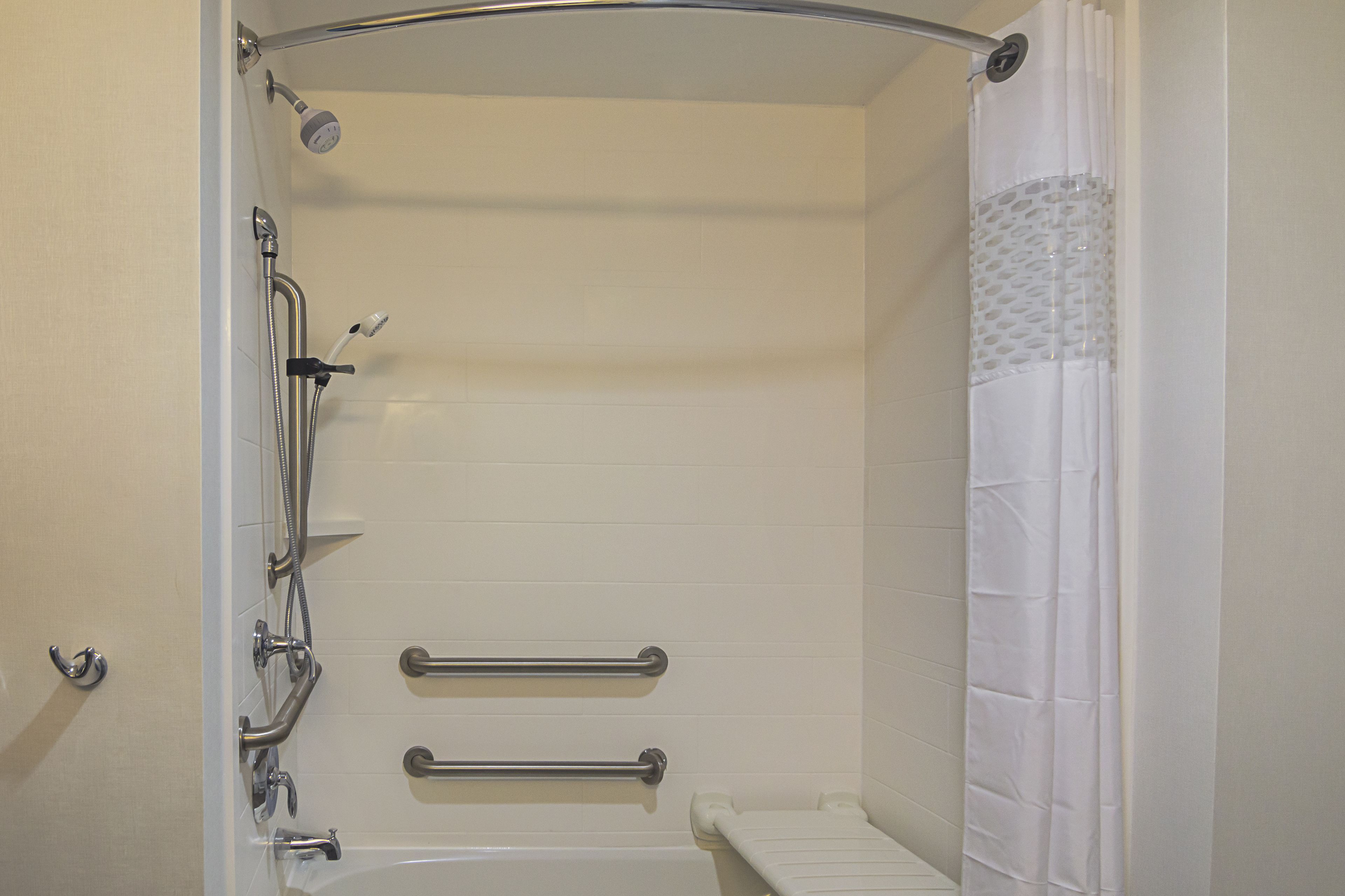 A shower with a handheld showerhead, a handheld shower nozzle, and a handheld shower attachment.