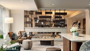 A modern living room with a fireplace, seating area, and a dining table.