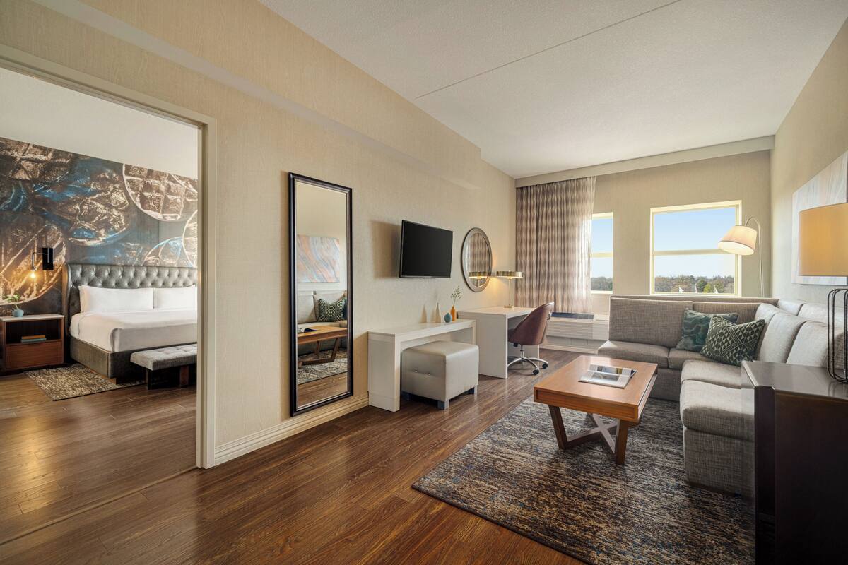 Une chambre d’hôtel moderne équipée d’un grand lit, d’un bureau, d’un canapé et d’une télévision.