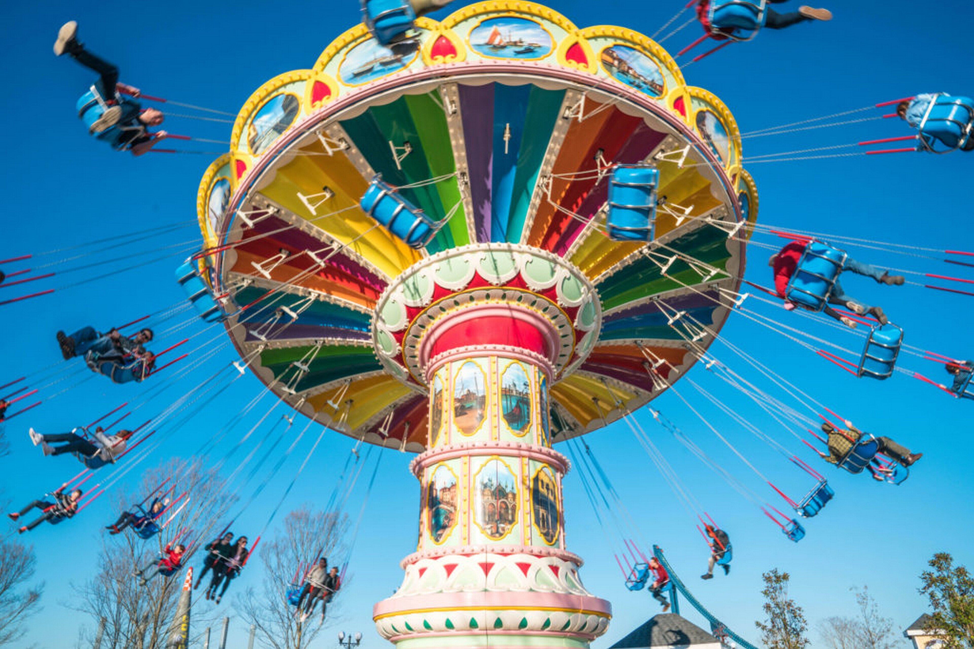 A carousel with multiple seats and riders.