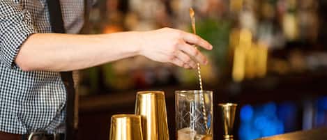 A bartender pouring a drink into a glass.