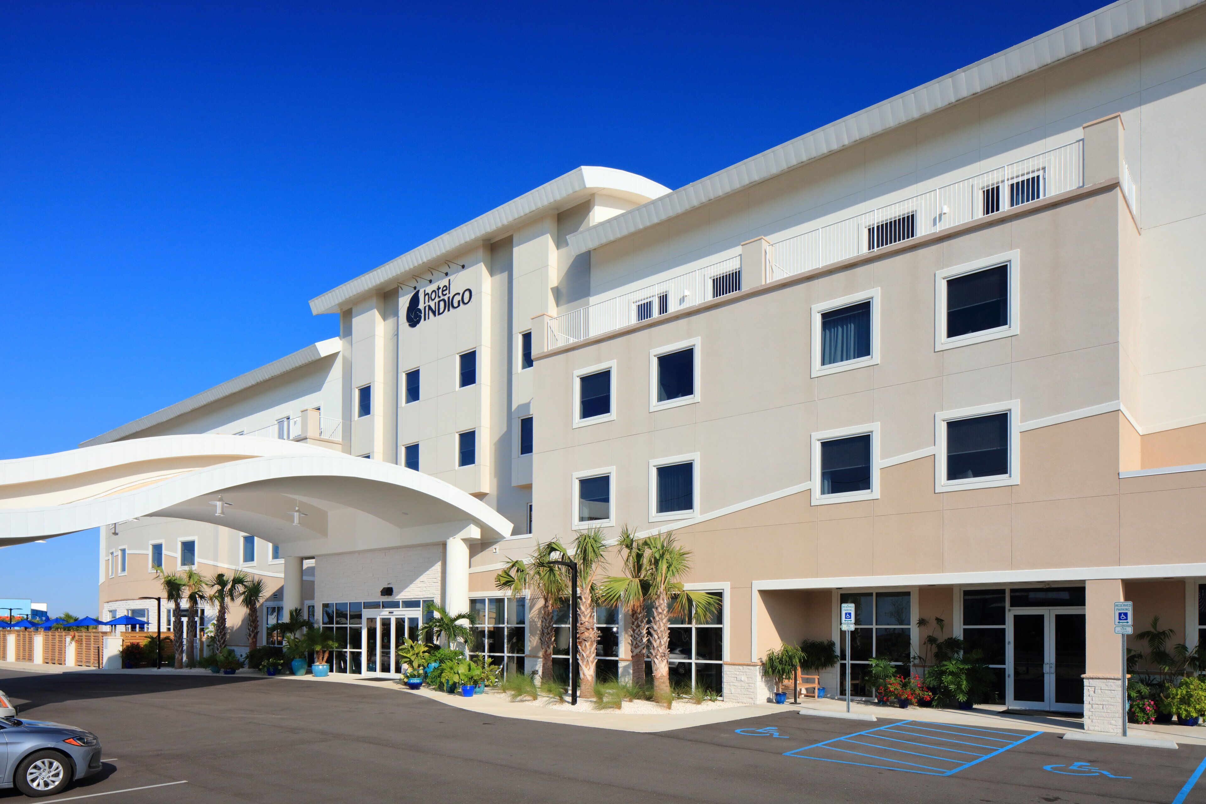 A hotel with a modern design, featuring a flat roof, large windows, and a covered entrance area.
