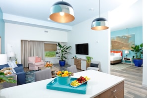 Una habitación de hotel moderna con comedor, sala de estar y dormitorio.