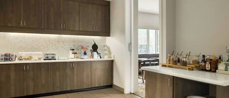 A modern kitchen with wooden cabinets, a white countertop, and a breakfast bar.