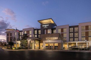 Un hotel moderno con techo plano, amplias ventanas y un letrero llamativo del Residence Inn by Marriott.