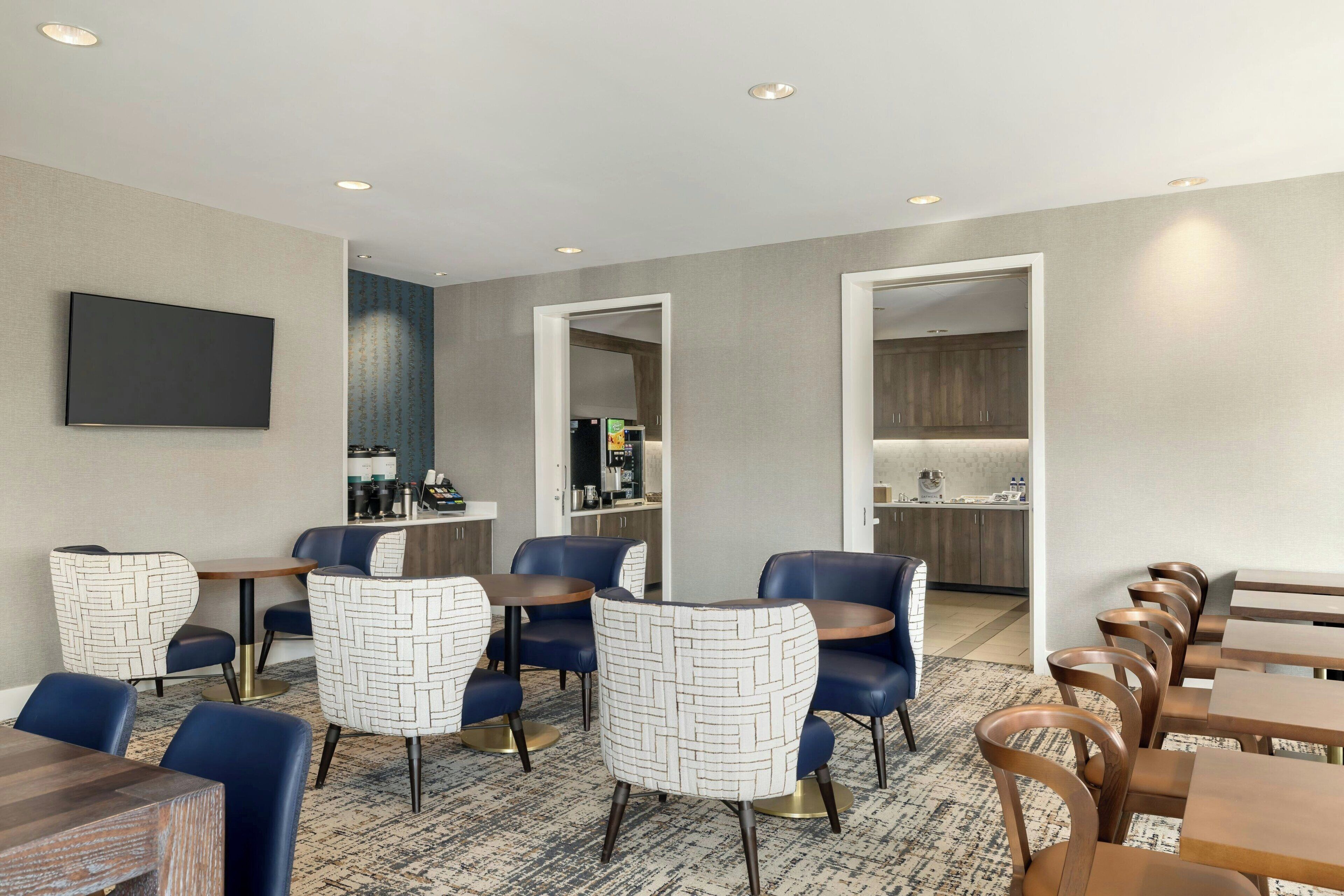 Une chambre d’hôtel avec un grand lit, un bureau et une chaise. Il y a une fenêtre donnant sur la ville.