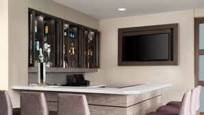 Eine moderne Küche mit Bar, Barhocker, Flachbildfernseher und Weinkühler.