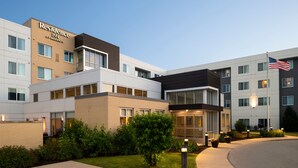 Ein modernes Hotel mit flachem Dach, großen Fenstern und einem gepflegten Rasen.