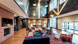 A spacious lobby with a fireplace, seating area, and large windows.