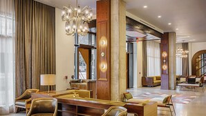 A spacious lobby with a central seating area, large windows, and a modern chandelier. - Thompson Nashville, by Hyatt (Nashville)