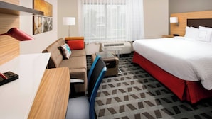 A hotel room with a bed, a desk, a chair, a sofa, and a window with sheer curtains. - TownePlace Suites by Marriott Alexandria Fort Belvoir (Alexandria)