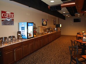 A hotel lobby with a coffee station, Aquafina water dispenser, and a patterned carpet. - Hotel At Batavia Downs (Batavia)