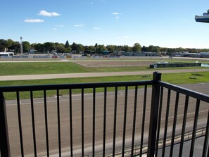 A view of a racetrack with a clear sky, surrounded by greenery and commercial buildings. - Hotel At Batavia Downs (Batavia)