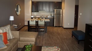 A modern apartment with a kitchen, dining area, and living room. - Hotel At Batavia Downs (Batavia)