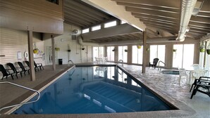An indoor swimming pool with a clear view of the ceiling structure, seating area, and windows. - Buffalo Ridge 2 Bed Loft (Silverthorne)