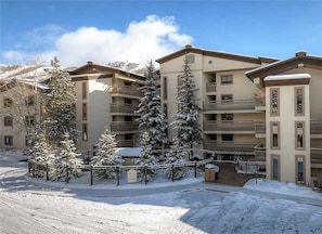 A multi-story hotel with balconies and a snow-covered courtyard. - 504 Dulany Apartment 3 SimplySteamboat (Steamboat Springs)