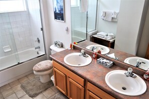 A bathroom with two sinks, a toilet, a shower, and a large mirror. - Forest Park 3 Bed 4 Bath Townhome (Silverthorne)