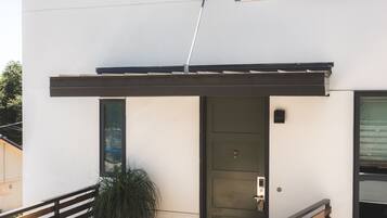 A modern building with a white exterior, a dark door, and a small window.