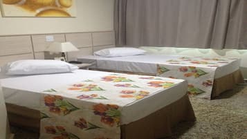 Ein Hotelzimmer mit zwei Einzelbetten, einem Nachttisch, einer Lampe und einem Bild an der Wand.
