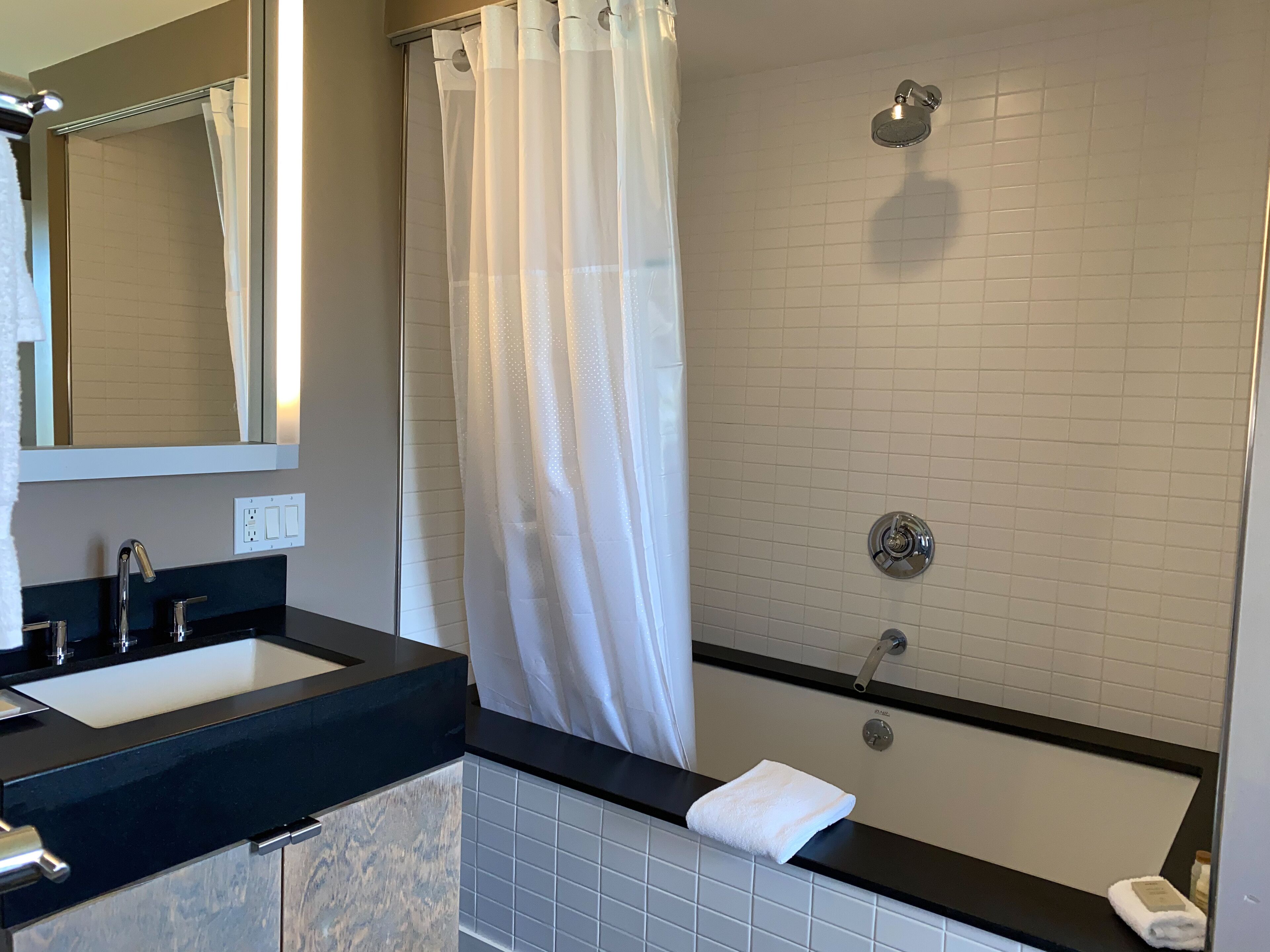 Un baño moderno con lavamanos doble, ducha y bañera.